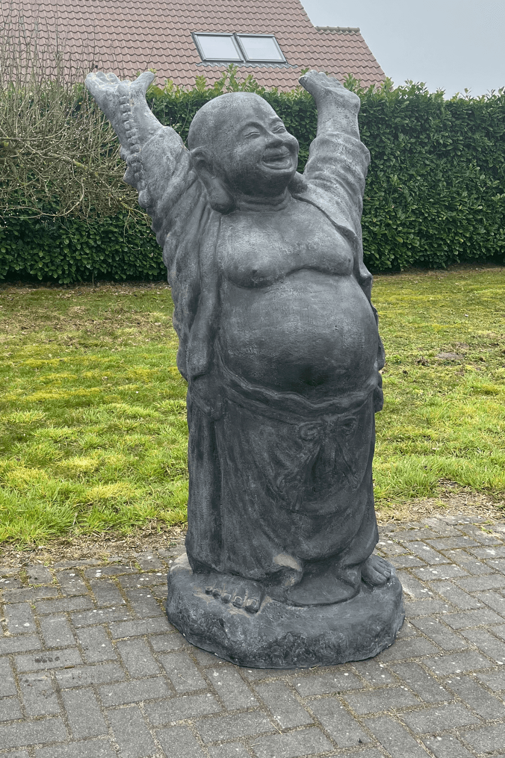 Stenen grote vrolijke boeddha voor in de tuin