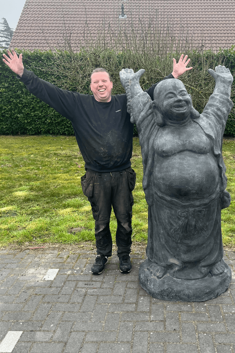 Stenen grote vrolijke boeddha voor in de tuin