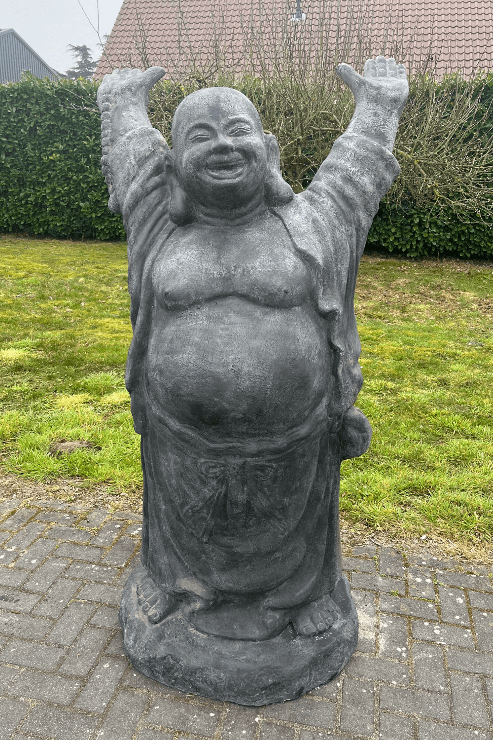 Stenen grote vrolijke boeddha voor in de tuin
