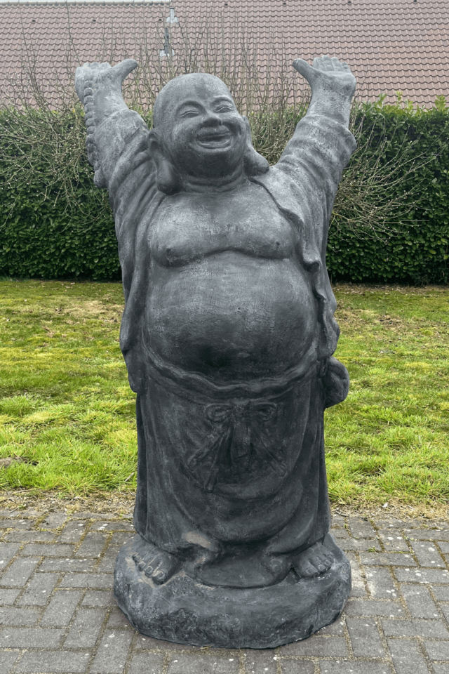 Stenen grote vrolijke boeddha voor in de tuin