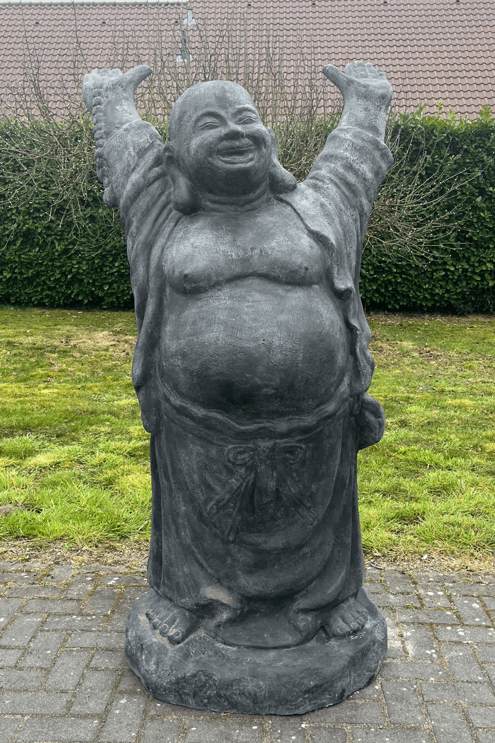 Stenen grote vrolijke boeddha voor in de tuin