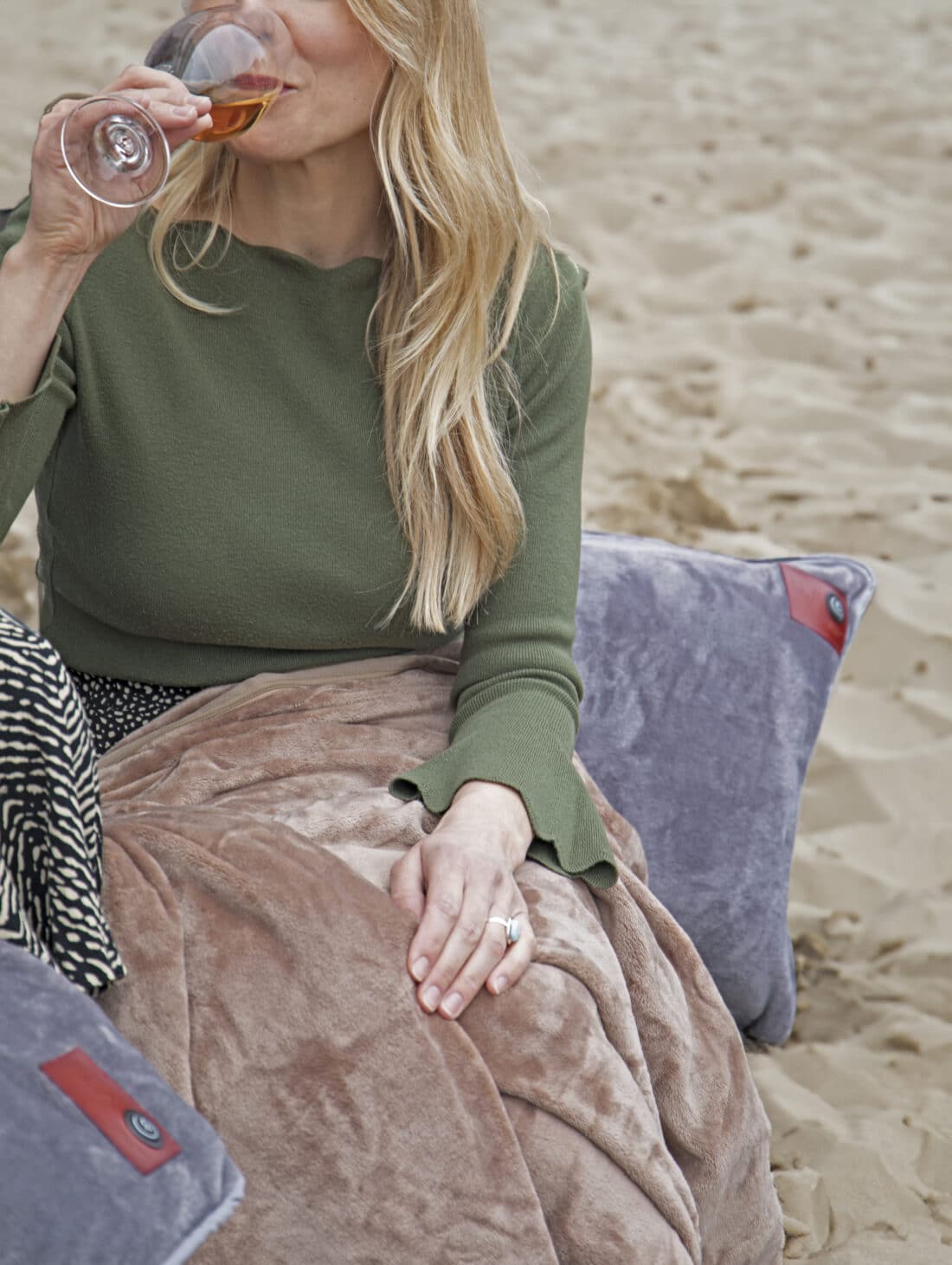 Eine Dame genießt die Infrarot-Wärmedecke und das Wärmekissen am Strand