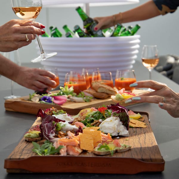drankenkoeler gevild met bierflesjes op een tafel samen met borrelplanken gevuld met lekkere hapjes drankenkoeler gevild met bierflesjes op een tafel samen met borrelplanken gevuld met lekkere hapjes