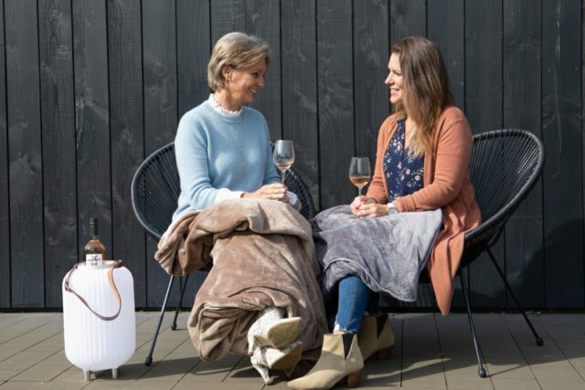 les dames boivent des roses dans le jardin au printemps et sont recouvertes d'une fine couverture chauffante à infrarouge