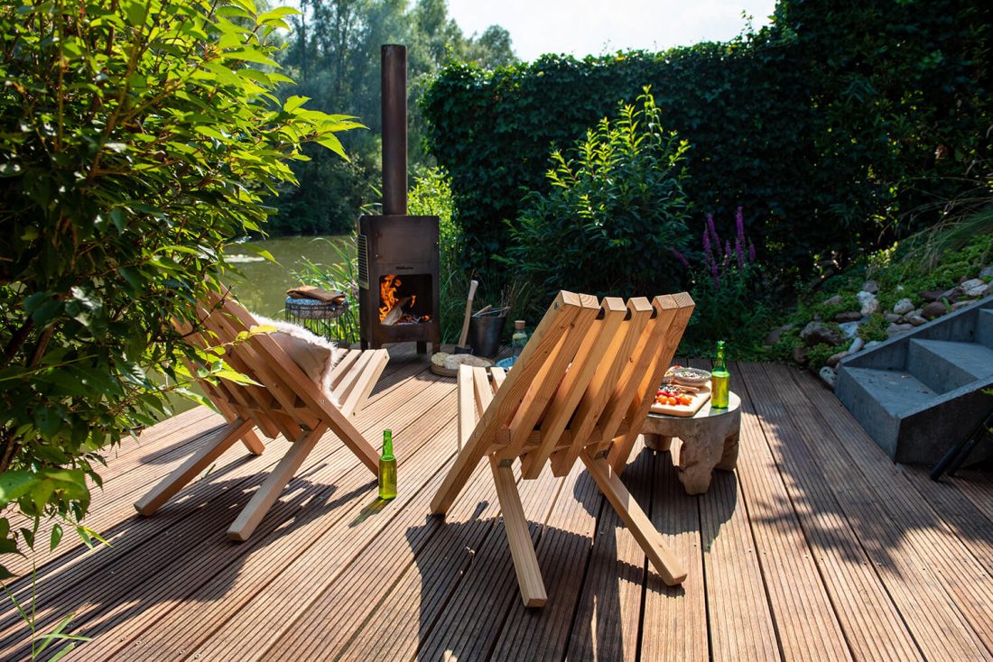 Húndete en una silla de campo junto al horno exterior