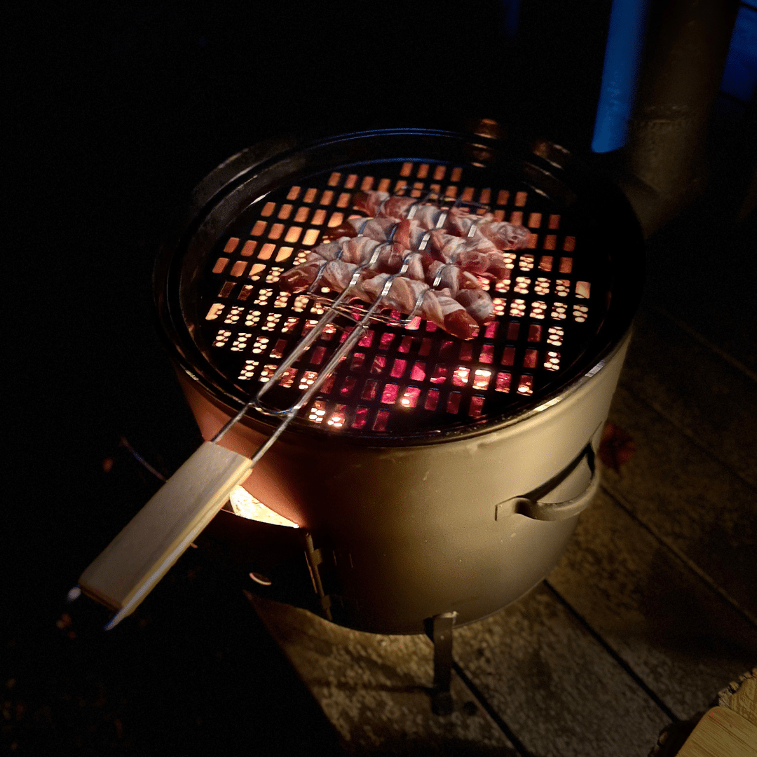 grillrooster voor worstjes met merquez worstjes omwikkelt met ontbijtspek