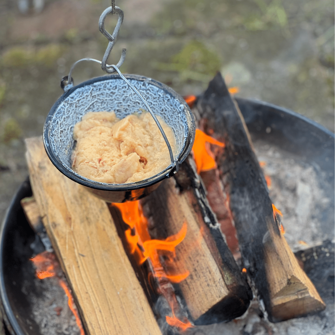 Hühnerragout in einem kleinen Mini-Hexenkessel über dem Lagerfeuer