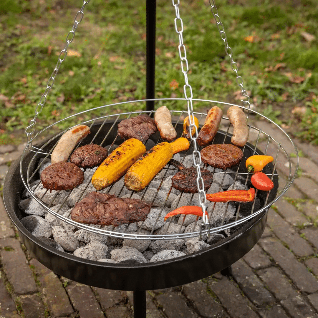 Driepoot met grillrooster en vuurschaal briketten en food